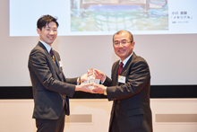 グランプリ受賞の小川さんへ 岡田副社長よりトロフィーの授与